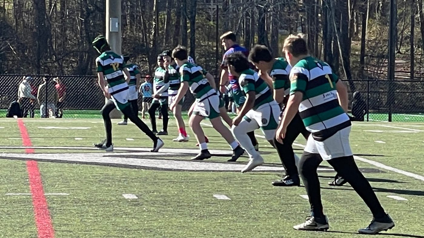 Rebels high school players in green and white hooped jerseys during match play