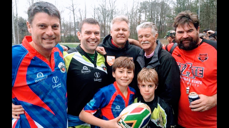 Coach Nico, Coach Gareth, and Coach Daan with their sons Nico and Toby in the early Rebels Rugby days. The boys are 2026 graduating seniors.