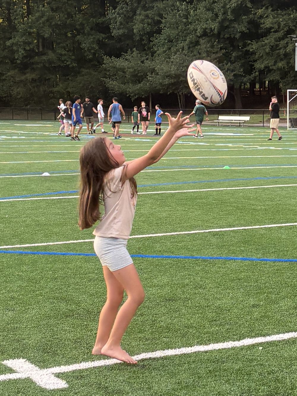 A young Rebel reaching up to catch a rugby ball